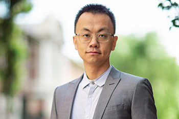 Prof Tianyi Ma in grey suit looking into camera wearing glasses. Photo credit: RMIT